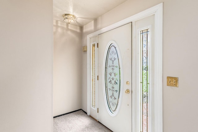 carpeted foyer with baseboards