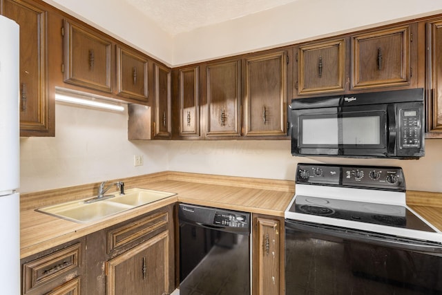 kitchen with a sink, black appliances, and a textured ceiling
