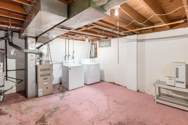 unfinished below grade area with electric panel, heating unit, water heater, separate washer and dryer, and visible vents