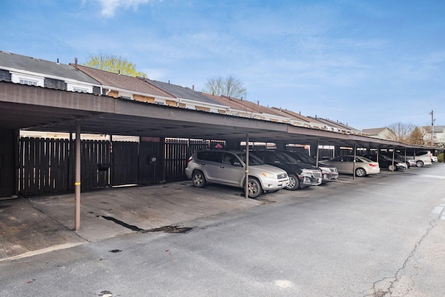 covered parking lot featuring fence