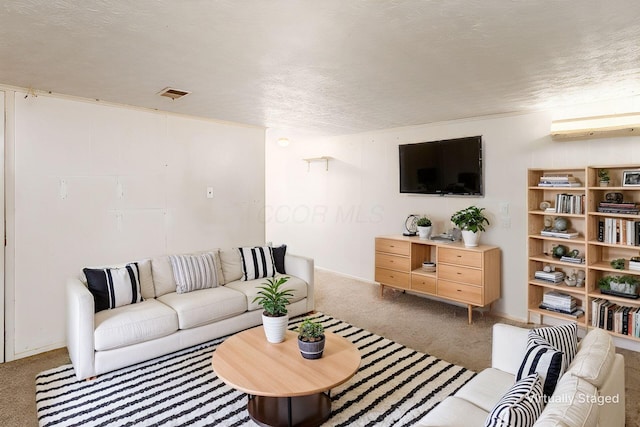 living area featuring visible vents, carpet flooring, and a textured ceiling