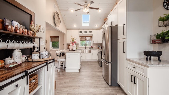 5456 Skyline Dr, Cambridge, OH 43725 - kitchen with white cabinets, a kitchen bar, stainless steel appliances, and ceiling fan