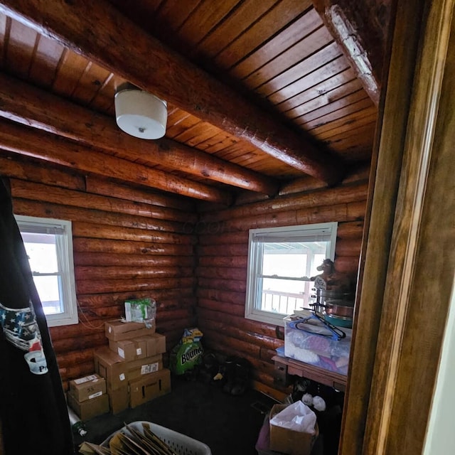 interior space with rustic walls, multiple windows, beam ceiling, and wood ceiling