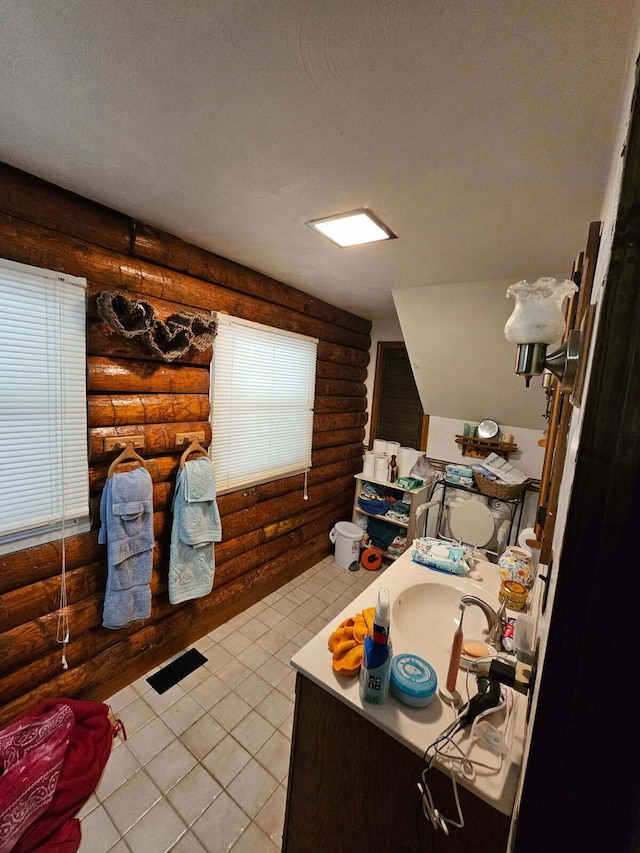bathroom featuring vanity, rustic walls, tile patterned flooring, a textured ceiling, and toilet