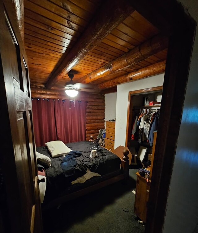 bedroom featuring log walls, a closet, beamed ceiling, carpet, and wood ceiling