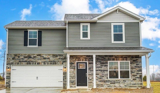 view of front of home featuring stone siding, a garage, and concrete driveway