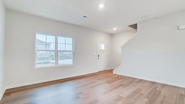 foyer with light wood finished floors, baseboards, visible vents, and recessed lighting