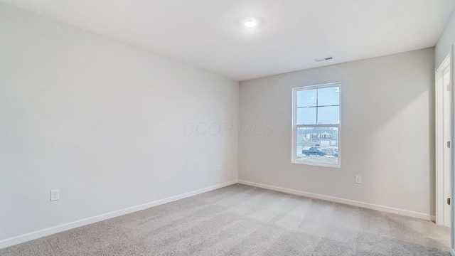 unfurnished bedroom with baseboards, visible vents, and light carpet