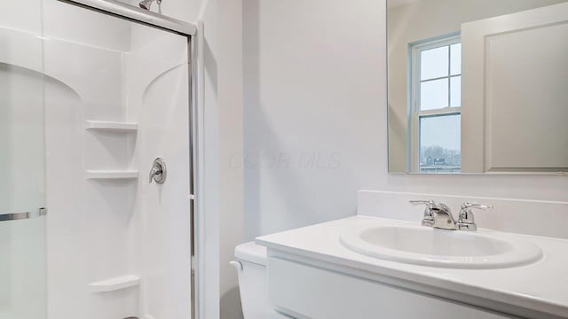 full bathroom with toilet, vanity, and an enclosed shower