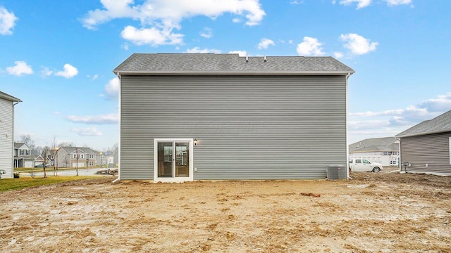 rear view of house featuring central AC and a residential view