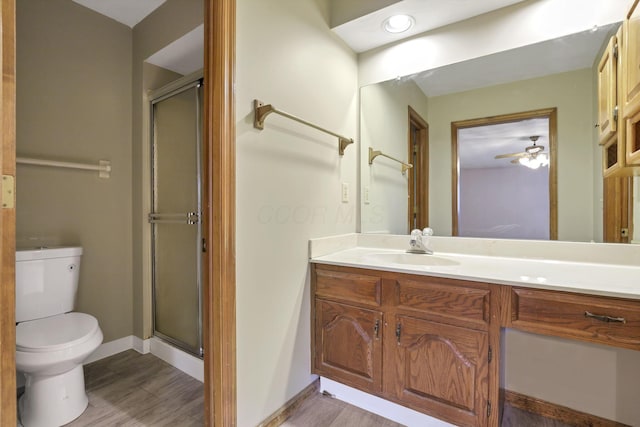 bathroom with toilet, a stall shower, and vanity