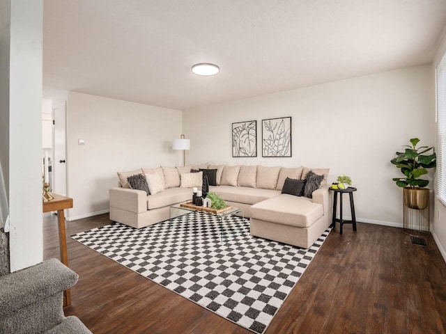 living area with visible vents, baseboards, and dark wood finished floors