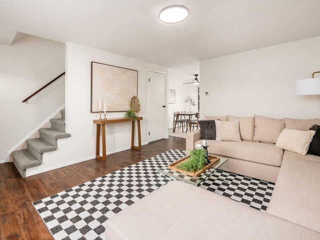 living area with baseboards, stairway, ceiling fan, and wood finished floors
