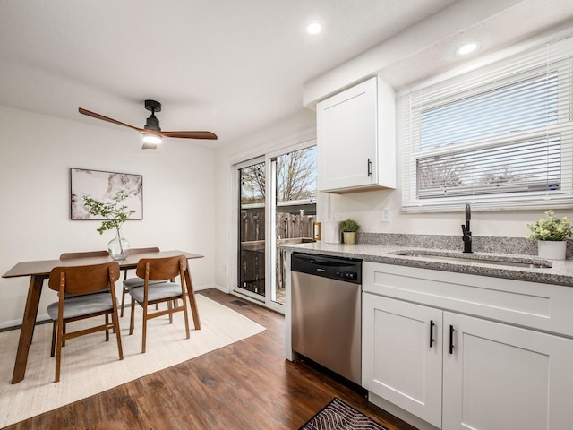 kitchen with dishwasher, light stone countertops, dark wood-type flooring, white cabinetry, and a sink
