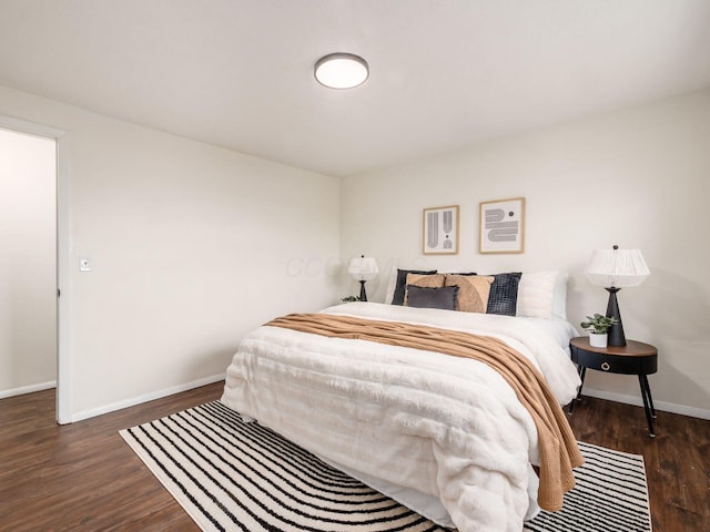 bedroom with baseboards and wood finished floors
