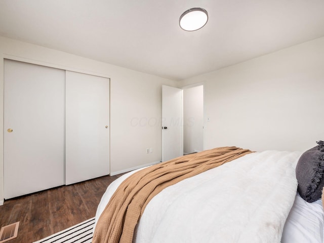 bedroom featuring visible vents, a closet, and wood finished floors