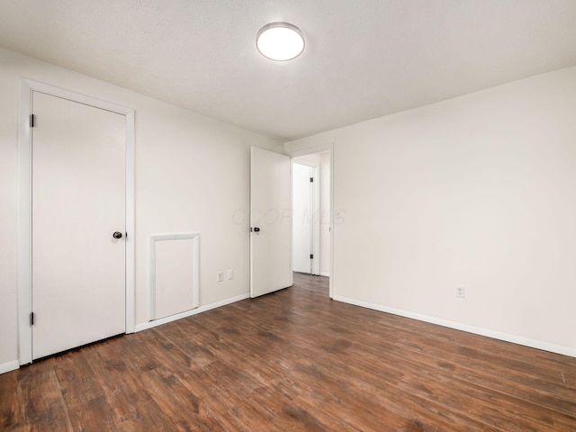 unfurnished room featuring baseboards and wood finished floors