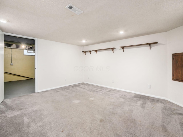 finished basement with a textured ceiling, visible vents, carpet, baseboards, and recessed lighting