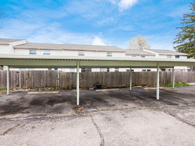 covered parking lot featuring fence
