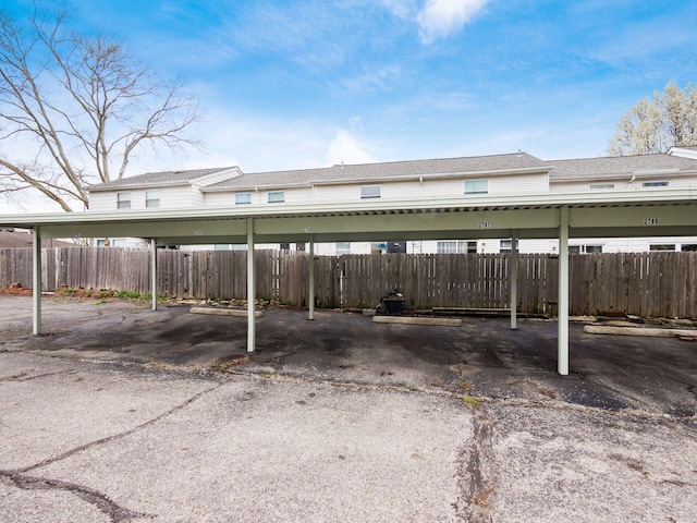 covered parking lot featuring fence