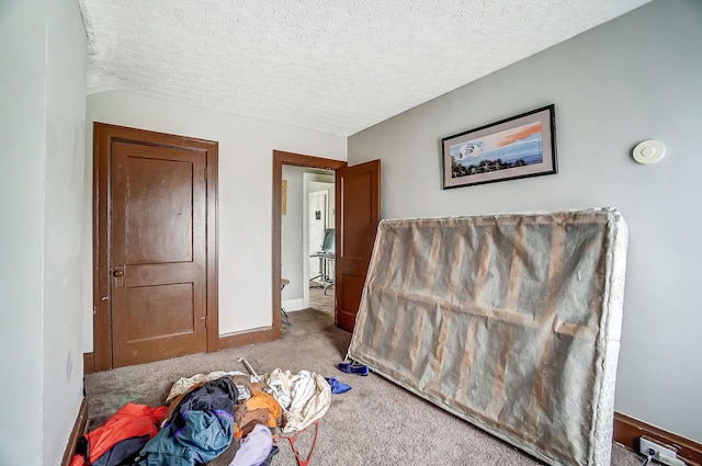 carpeted bedroom with a textured ceiling and baseboards