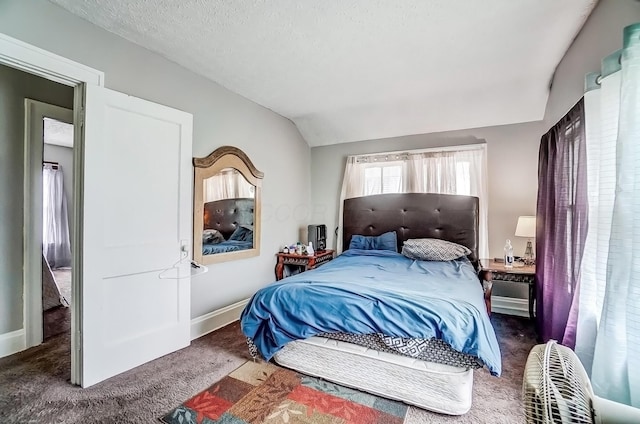 bedroom with a textured ceiling, baseboards, carpet, and lofted ceiling