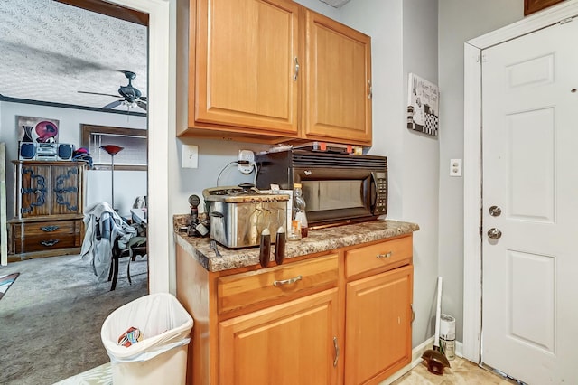 kitchen featuring light carpet, black microwave, and ceiling fan