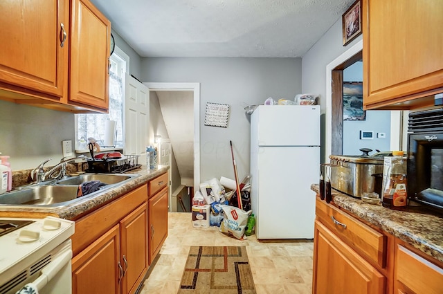 kitchen featuring white appliances, brown cabinets, and a sink
