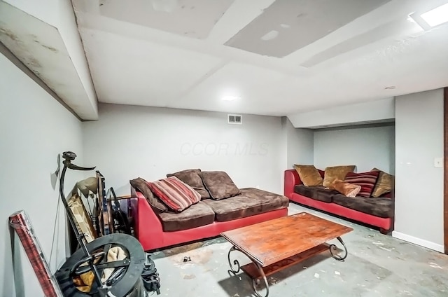 living room with unfinished concrete floors and visible vents
