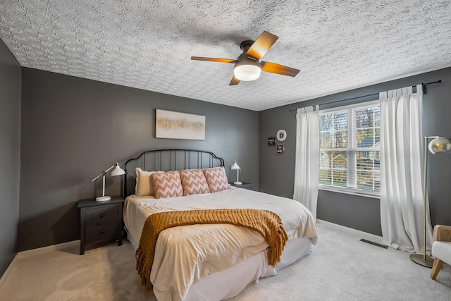 bedroom with a textured ceiling, ceiling fan, baseboards, and carpet