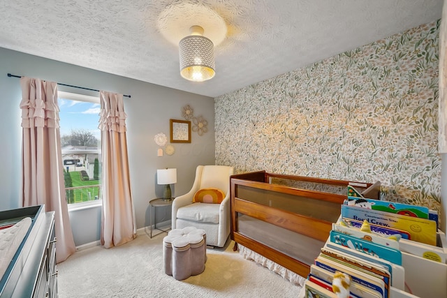 carpeted bedroom with a textured ceiling, wallpapered walls, and baseboards