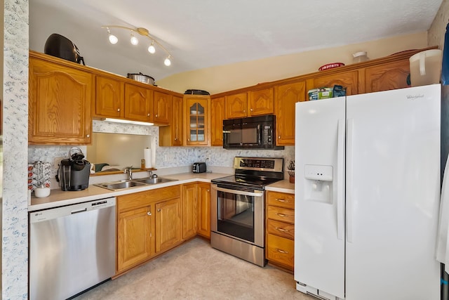 3588 Silverado Dr, Columbus, OH 43228 - kitchen with glass insert cabinets, a sink, light countertops, brown cabinets, and stainless steel appliances