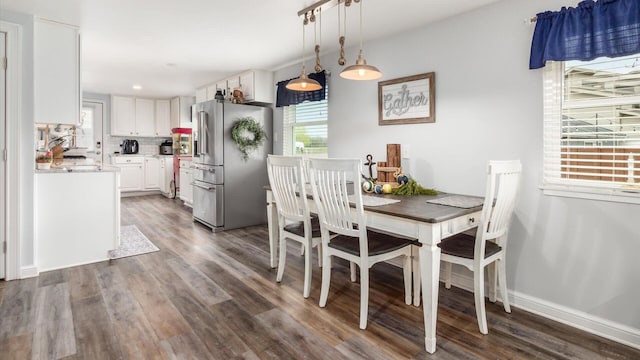 dining room featuring dark wood finished floors and baseboards