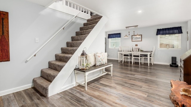 staircase featuring baseboards and wood finished floors