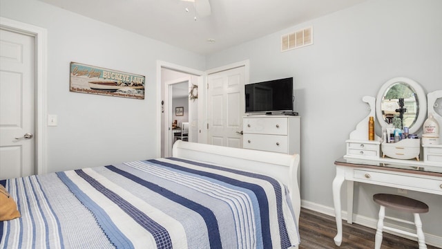 bedroom with a ceiling fan, wood finished floors, baseboards, and visible vents