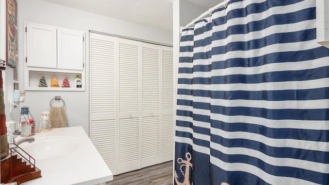 bathroom featuring curtained shower, wood finished floors, and vanity