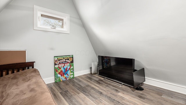 bonus room with baseboards, vaulted ceiling, and wood finished floors