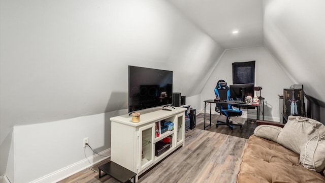 home office featuring baseboards, lofted ceiling, and wood finished floors