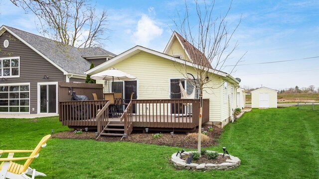 rear view of house featuring a lawn, a wooden deck, an outdoor structure, and a storage shed