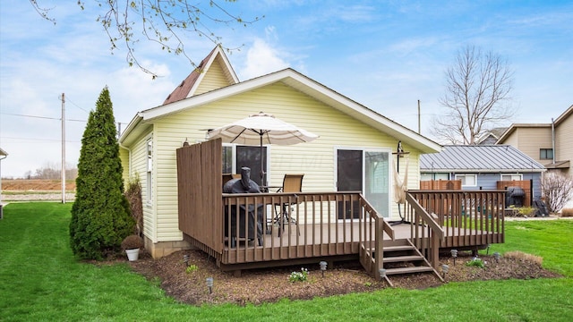 rear view of house featuring a yard and a wooden deck