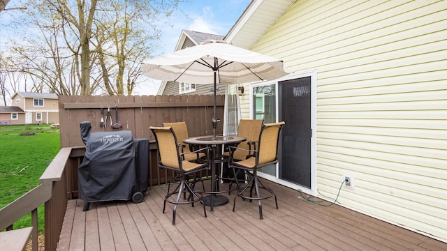 deck featuring grilling area, a yard, and outdoor dining space