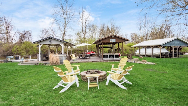 view of yard featuring a fire pit, a gazebo, and a hot tub
