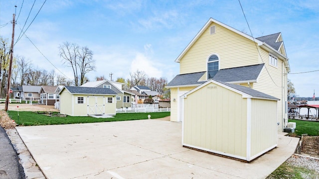 40 Beacon Light Ln, Buckeye Lake, OH 43008 - back of house with a shingled roof, a storage shed, a lawn, fence, and an outbuilding