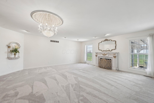 unfurnished living room with baseboards, carpet flooring, a notable chandelier, and visible vents