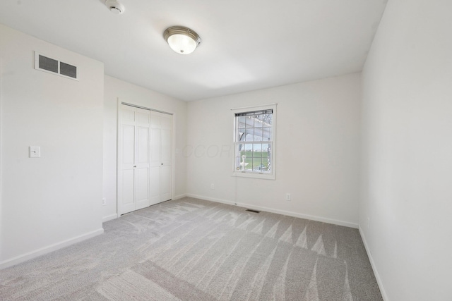 unfurnished bedroom with baseboards, visible vents, and carpet floors