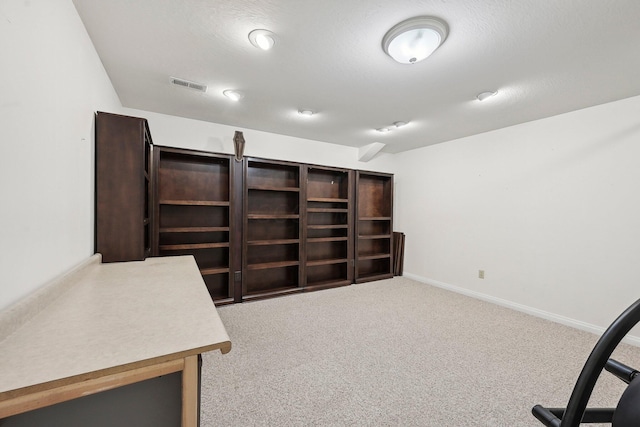 carpeted office featuring visible vents, baseboards, and a textured ceiling
