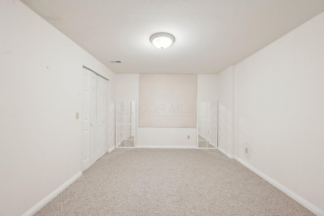 empty room featuring carpet flooring, baseboards, and visible vents