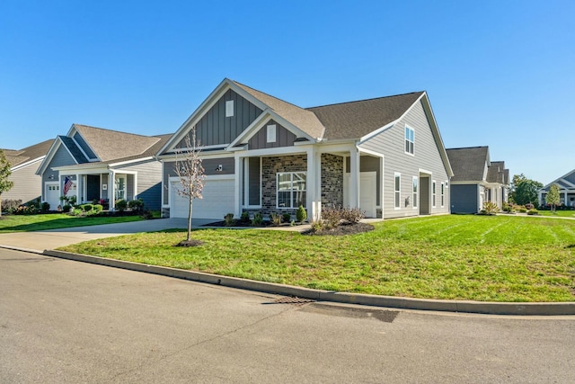 craftsman house featuring driveway, board and batten siding, stone siding, a front yard, and a garage
