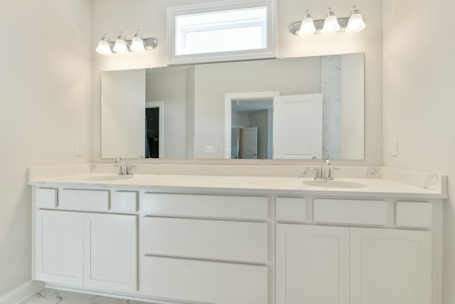 bathroom with double vanity, marble finish floor, and a sink