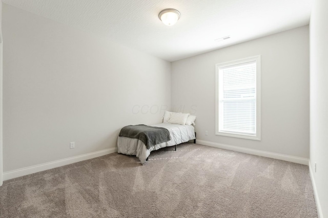 unfurnished bedroom with carpet, visible vents, and baseboards